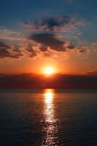 The sun setting at sea.