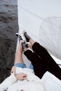 Two pairs of legs on the deck of a boat