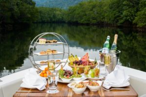 A table set with a lot of food and fruits on a boat.