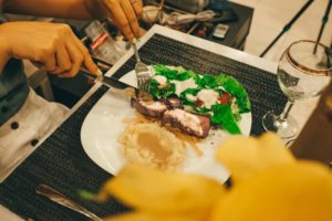 Woman digging into dinner with fancy cutlery