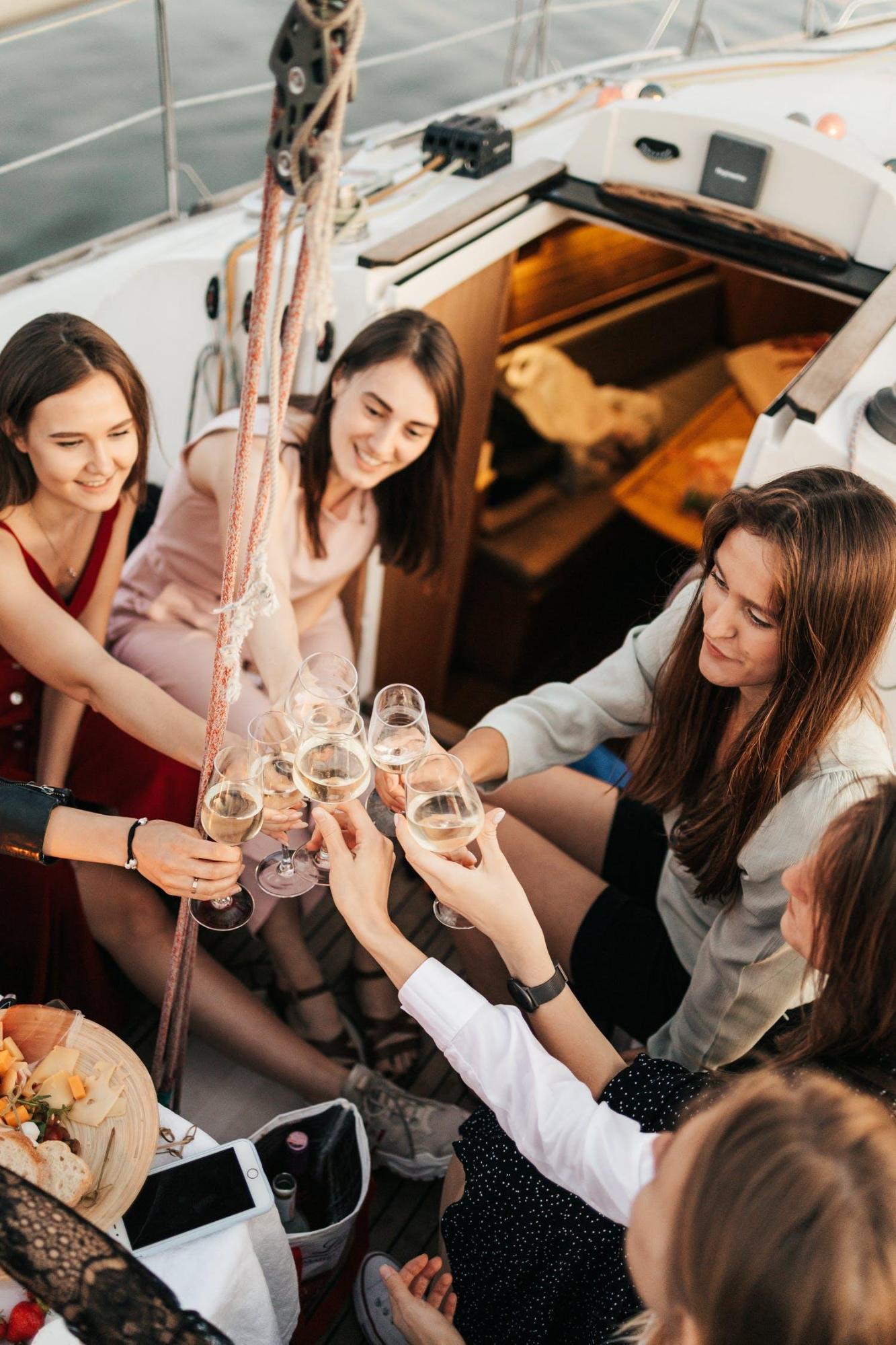 Women at a party in a yacht for rent, having fun, clinking their glasses