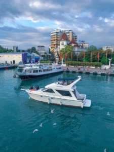 A white yacht in the sea and a ferry in the background